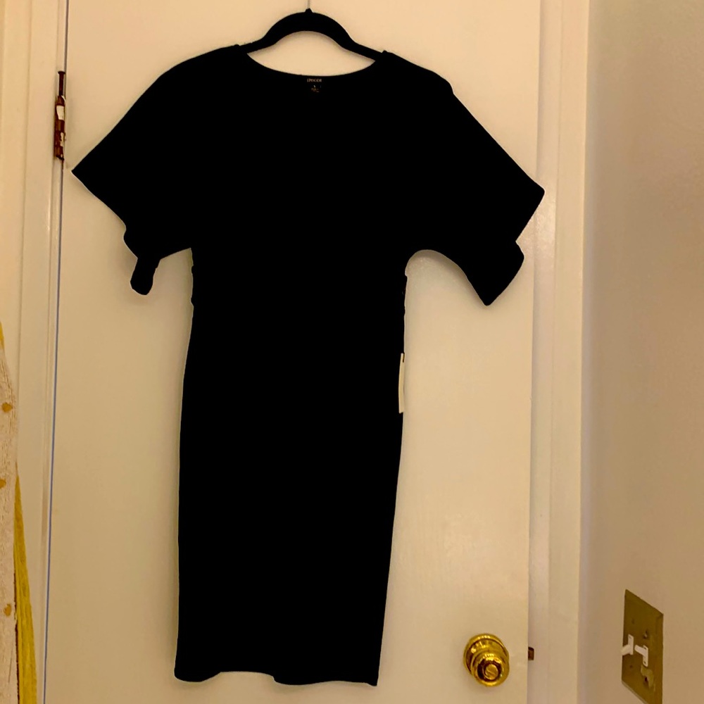 This stylish black dress has sexy bell sleeves and a plunging V neckline.